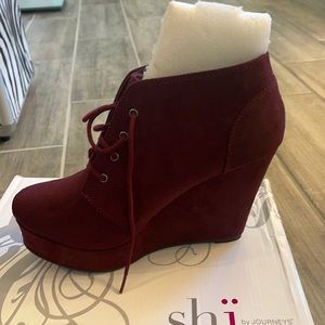 A burgundy suede wedge bootie